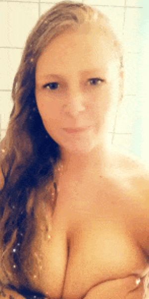 Sexy redhead holding her boobs in the shower